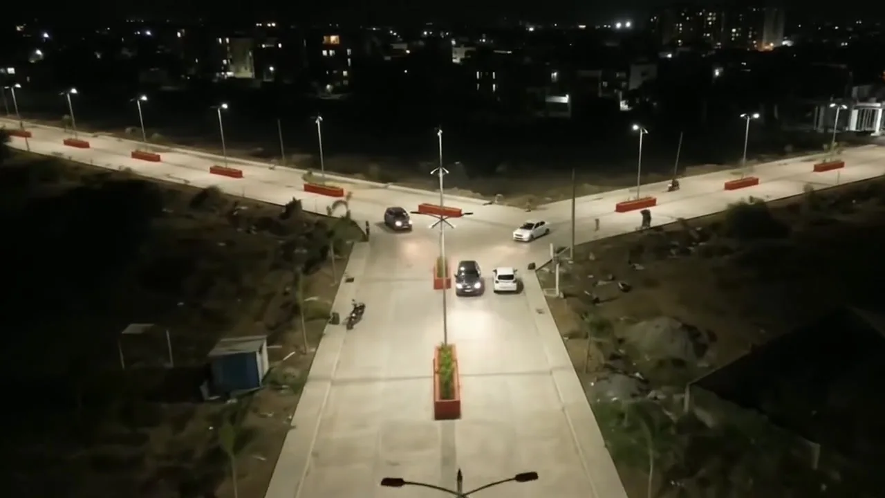 Evening view along Aastha's internal road, with street lights and a planted median